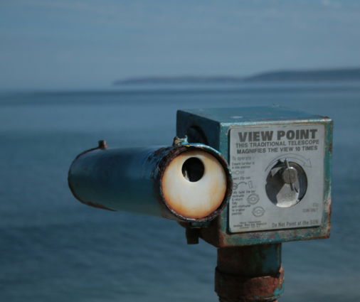 a metal object with a sign on it by the water